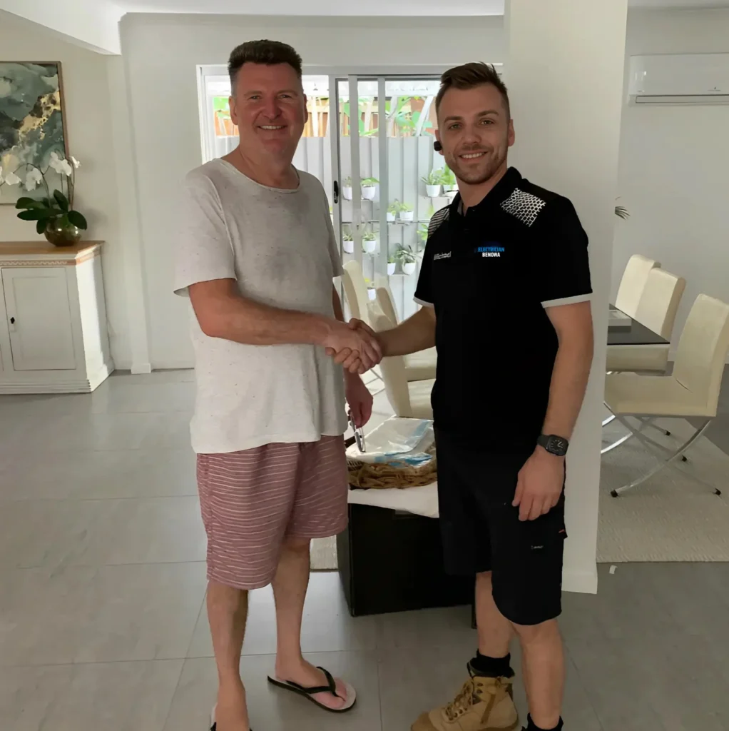 Two men shaking hands in a modern living room, one in casual clothes and the other in a uniform.