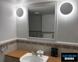 A bathroom sink with a mirror above it, featuring a modern design